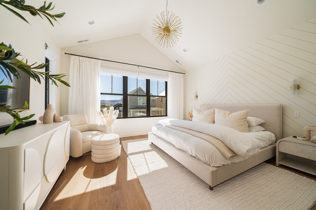 Sun-filled primary bedroom with king bed